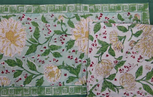 Floral patterned table runner with green border on a white background
