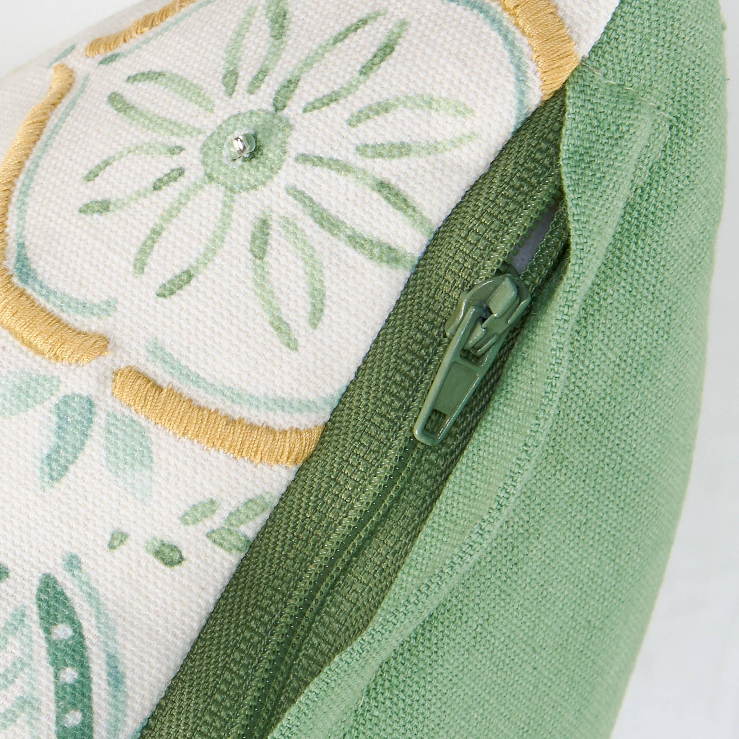 Close-up of a green zipper on a fabric with floral patterns