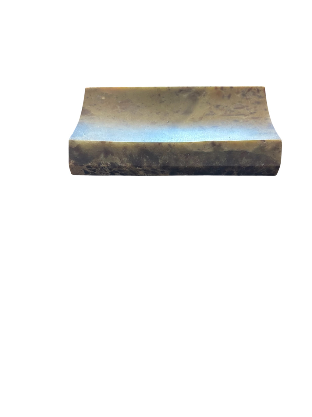 Side View of a soapstone soap dish. Rectangular concave shape neutral multi color.