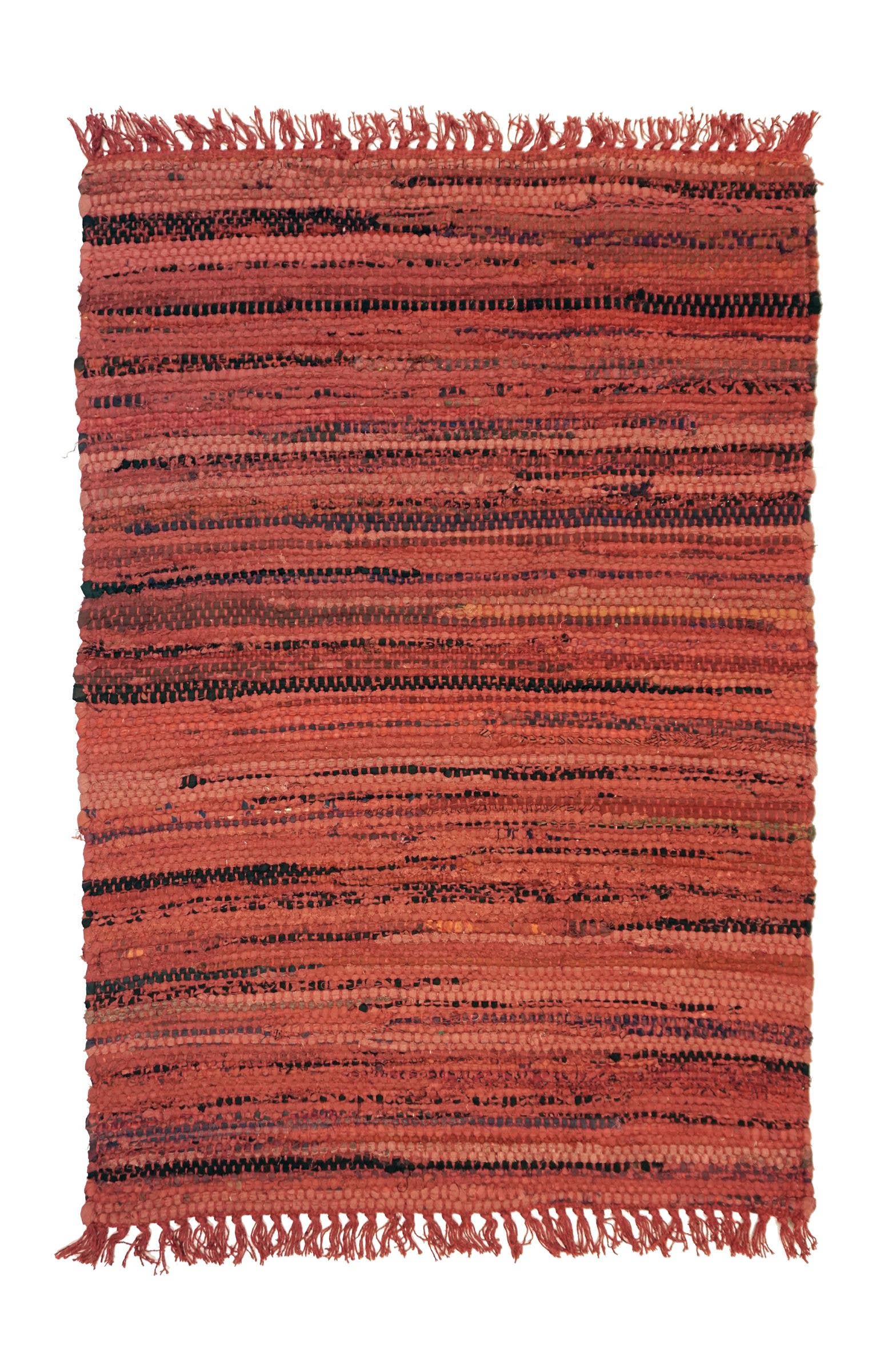 Textured red and black area rug with fringes on a plain background