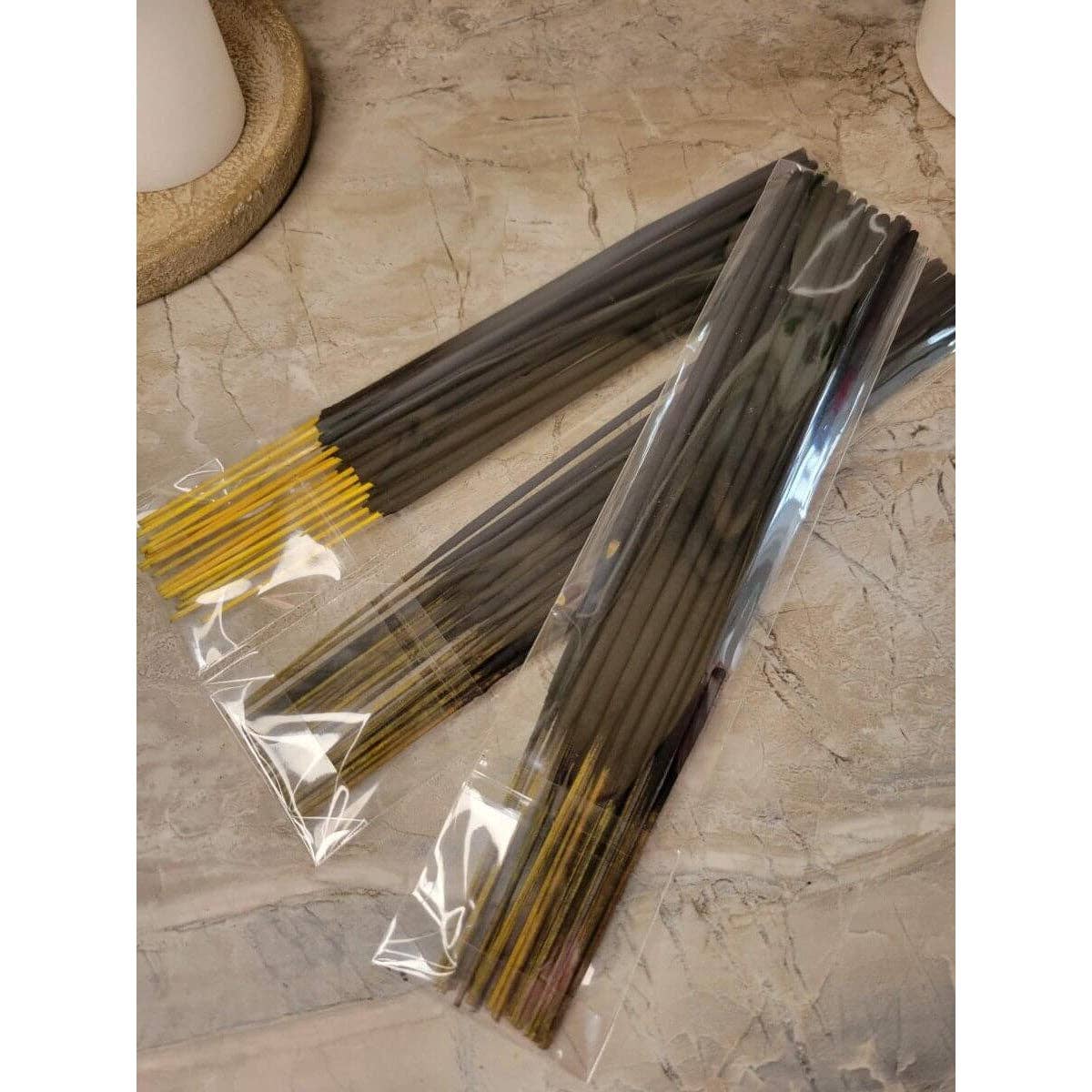 Incense sticks in clear packaging on a stone surface