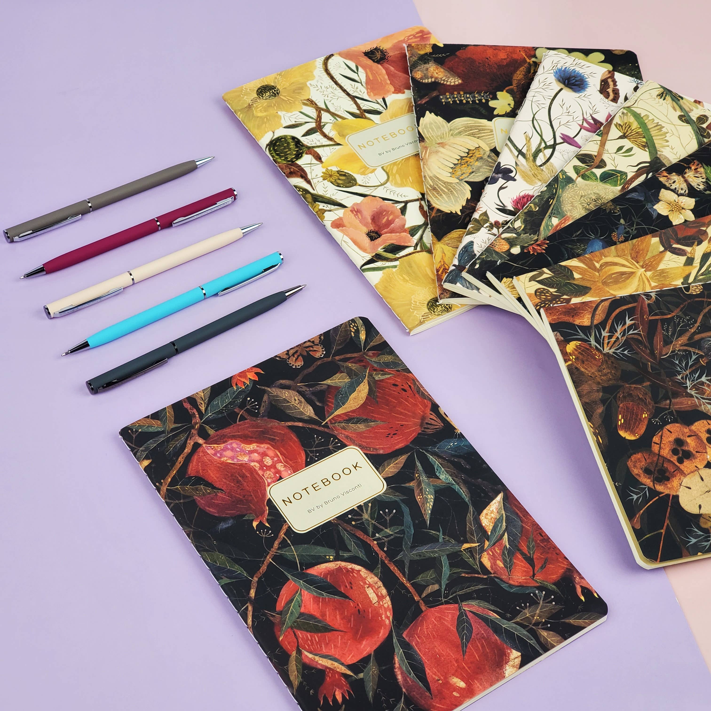 Floral notebooks and pens on a purple background