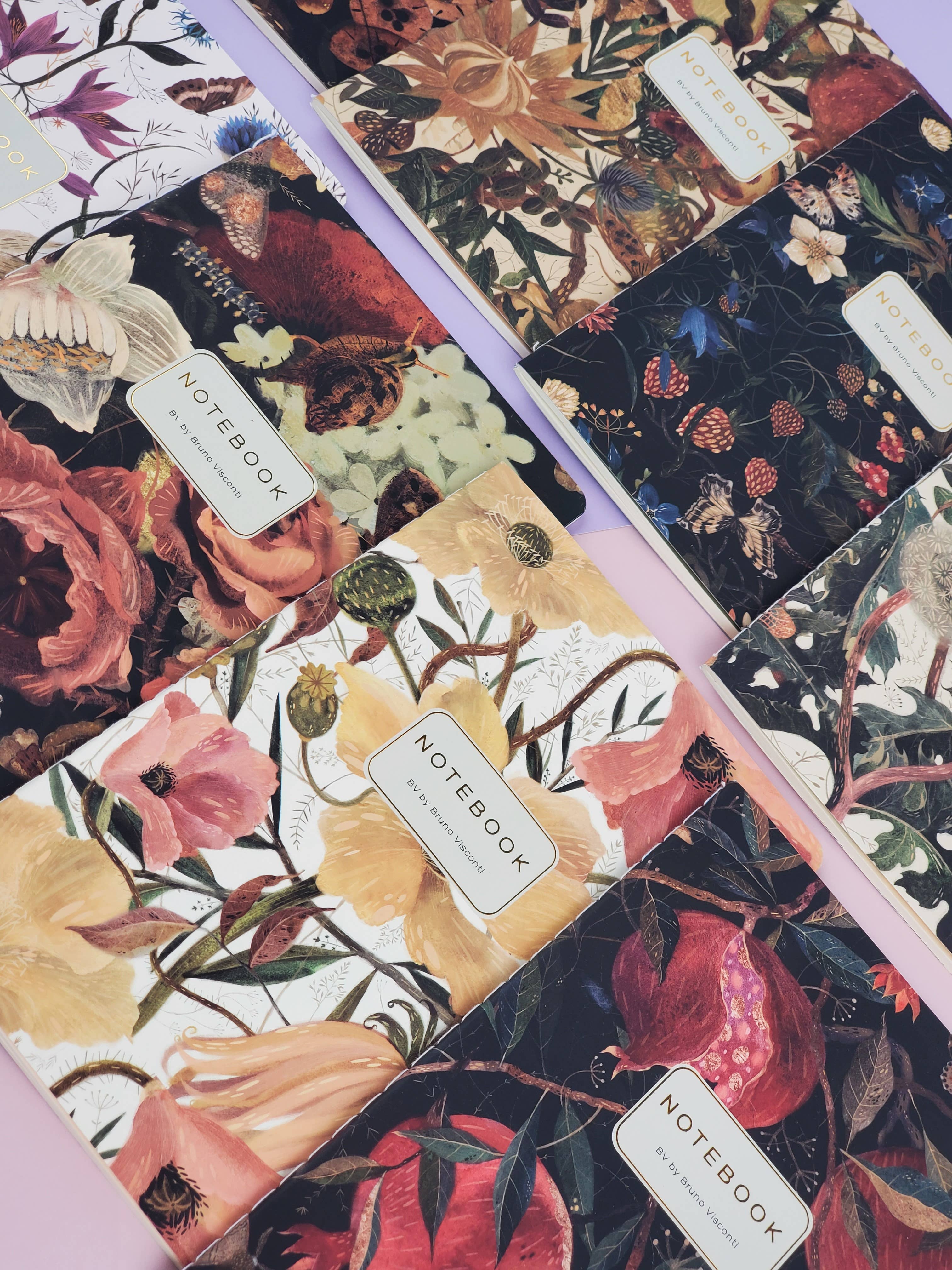 Collection of floral notebooks with visible brand labels.