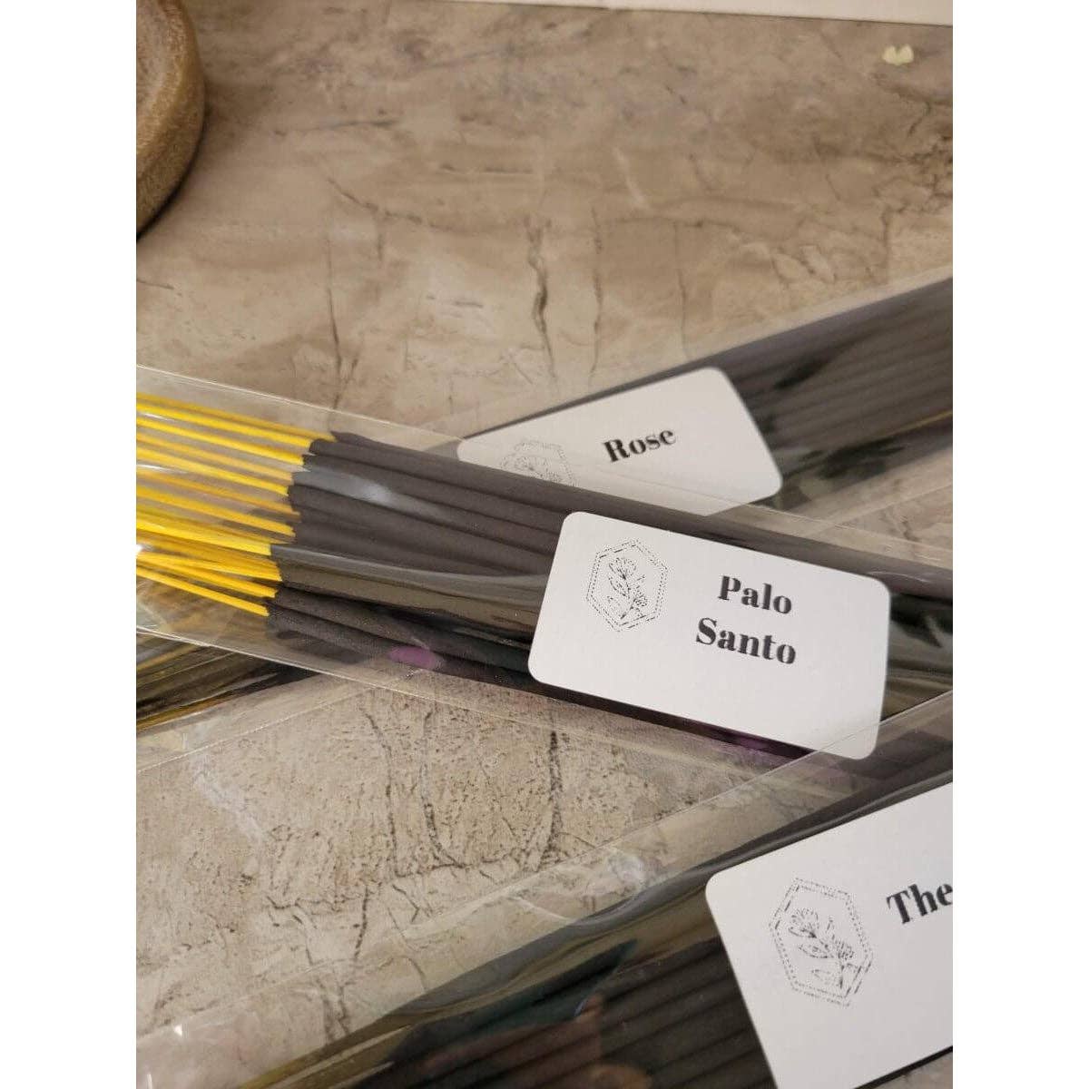 Palo Santo incense sticks with labels on a textured surface