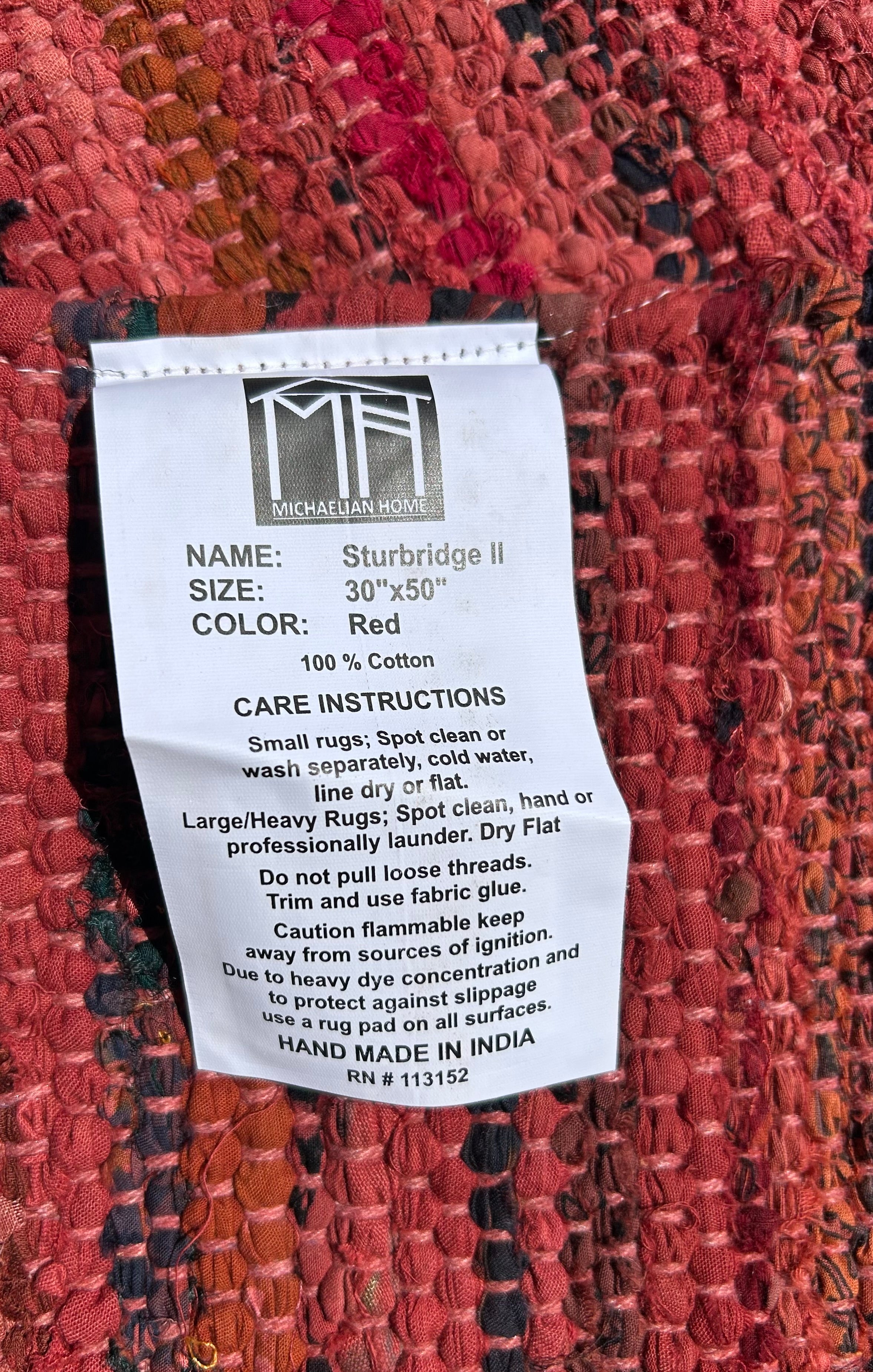 Label on a red rug with care instructions and product details.