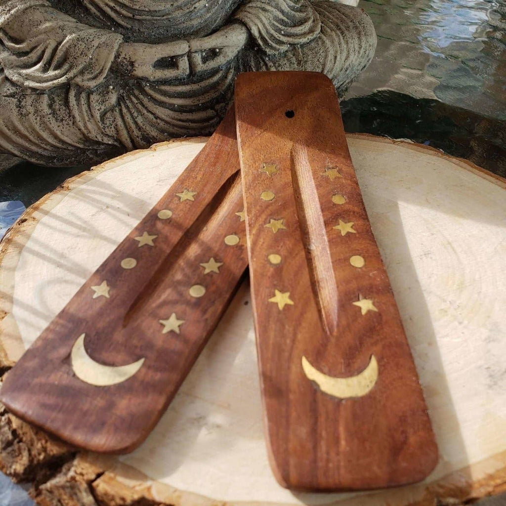 Wooden tools with star and moon designs on a stone surface