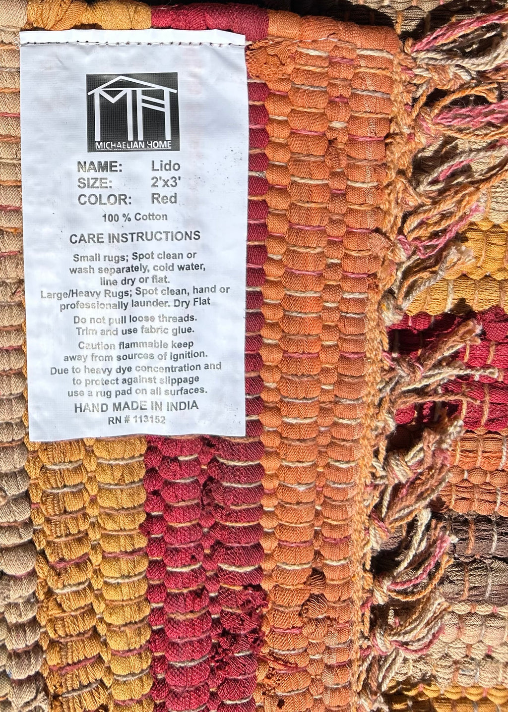 Textile product with a label detailing name, size, color, and care instructions.