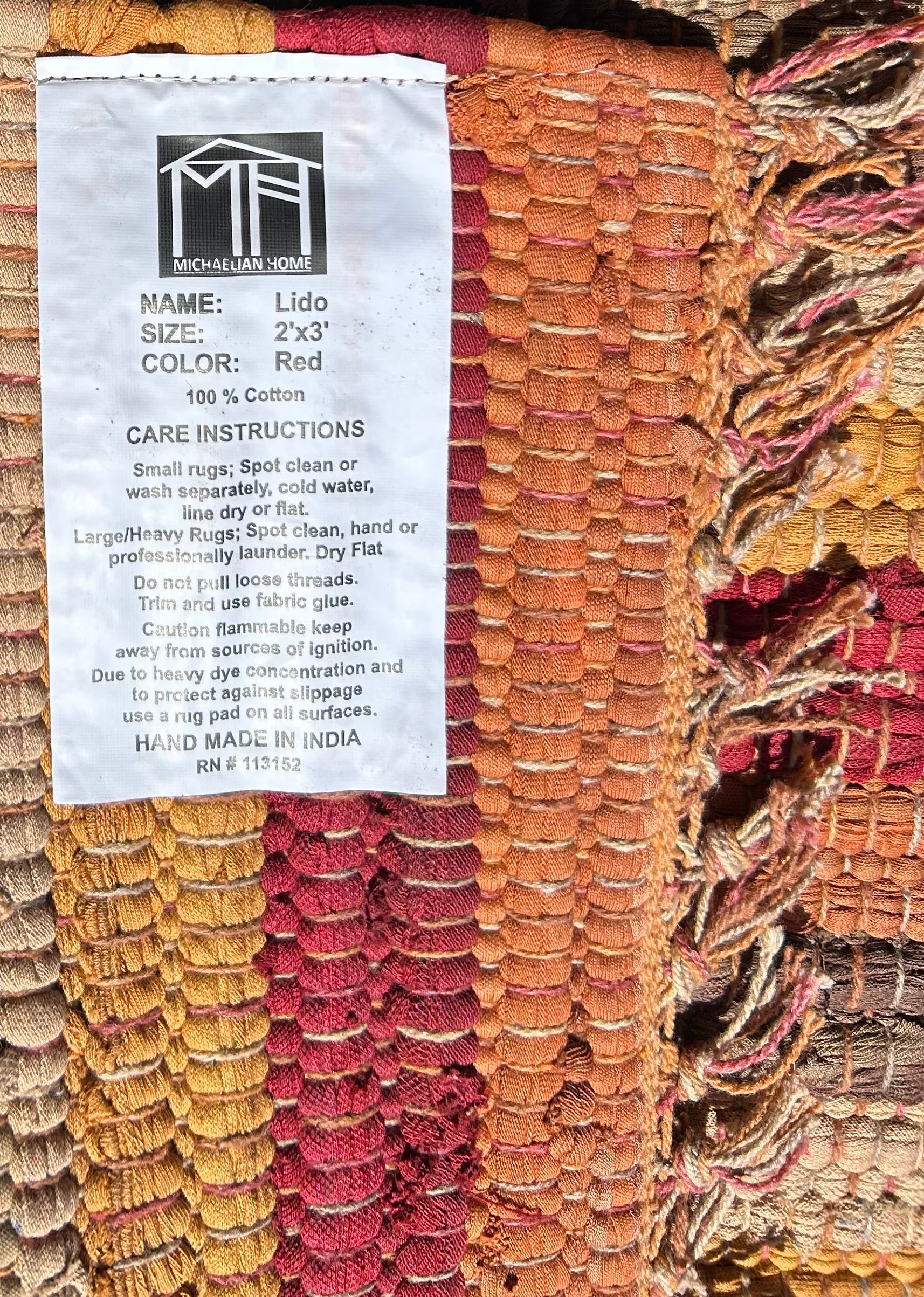 Textile product with a label detailing name, size, color, and care instructions.