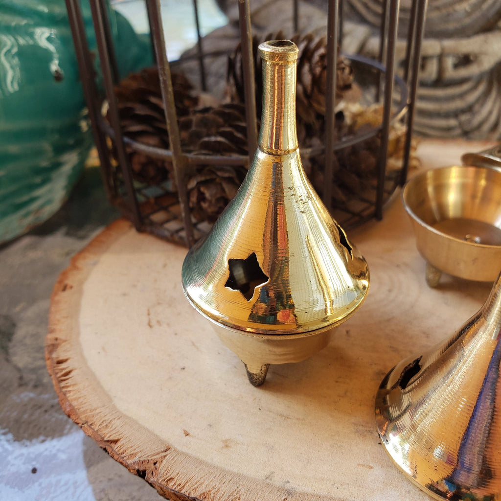 Brass incense burner on a wooden surface with a blurred background