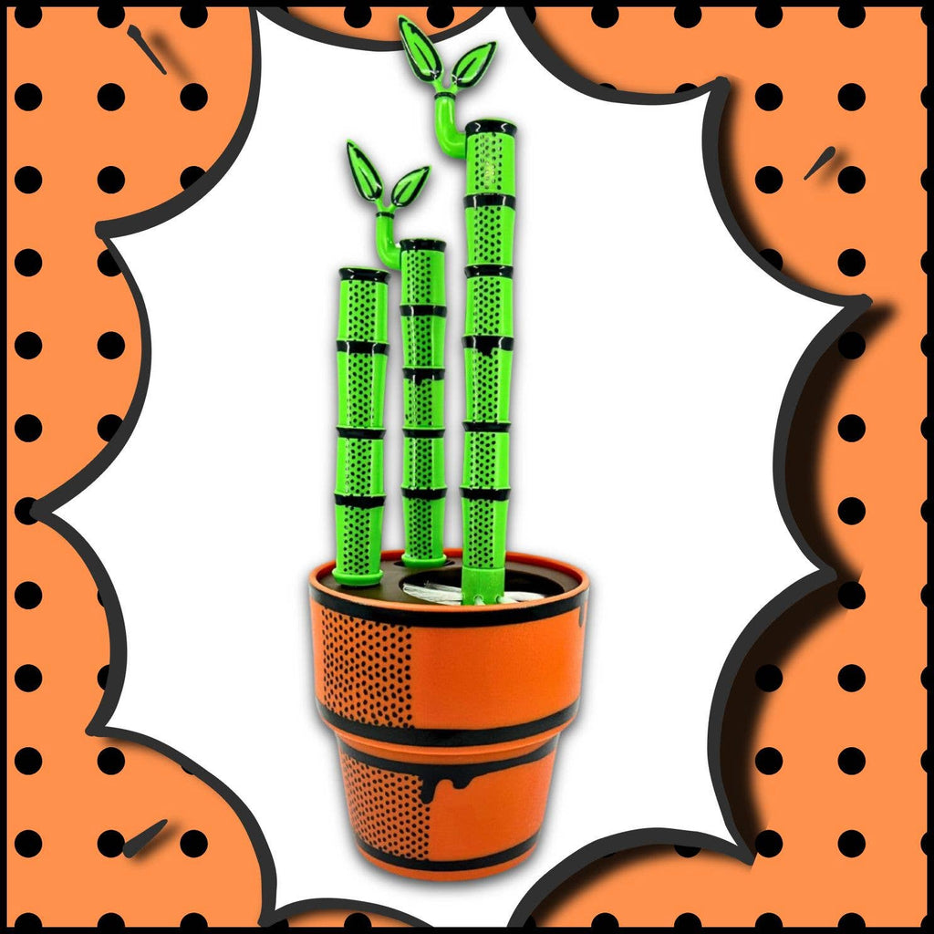 Potted plant with green bamboo-like stems in an orange pot against a white background