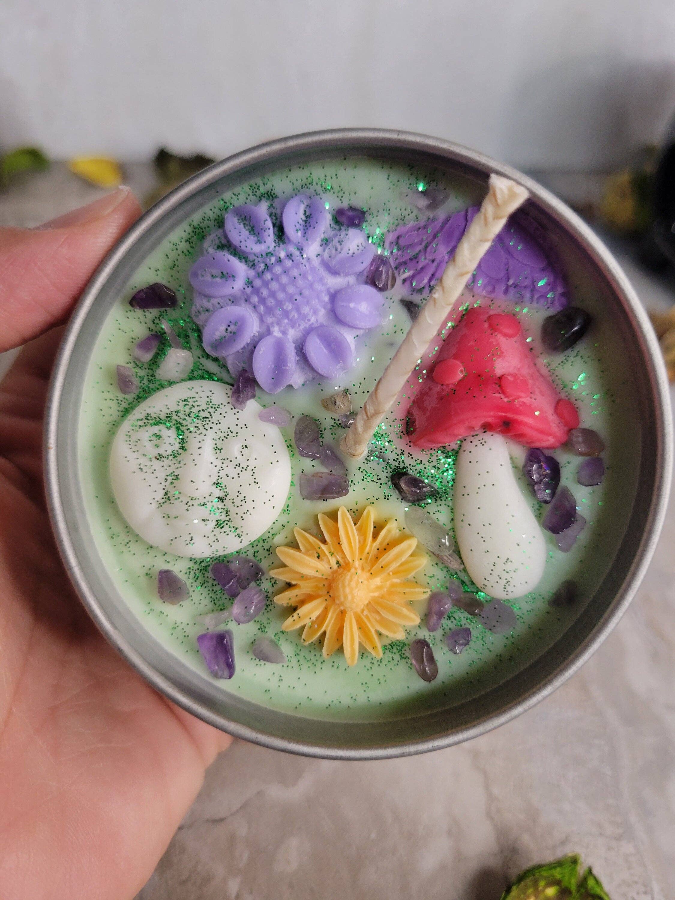 Hand holding a container with colorful Soy Candle  on a light background