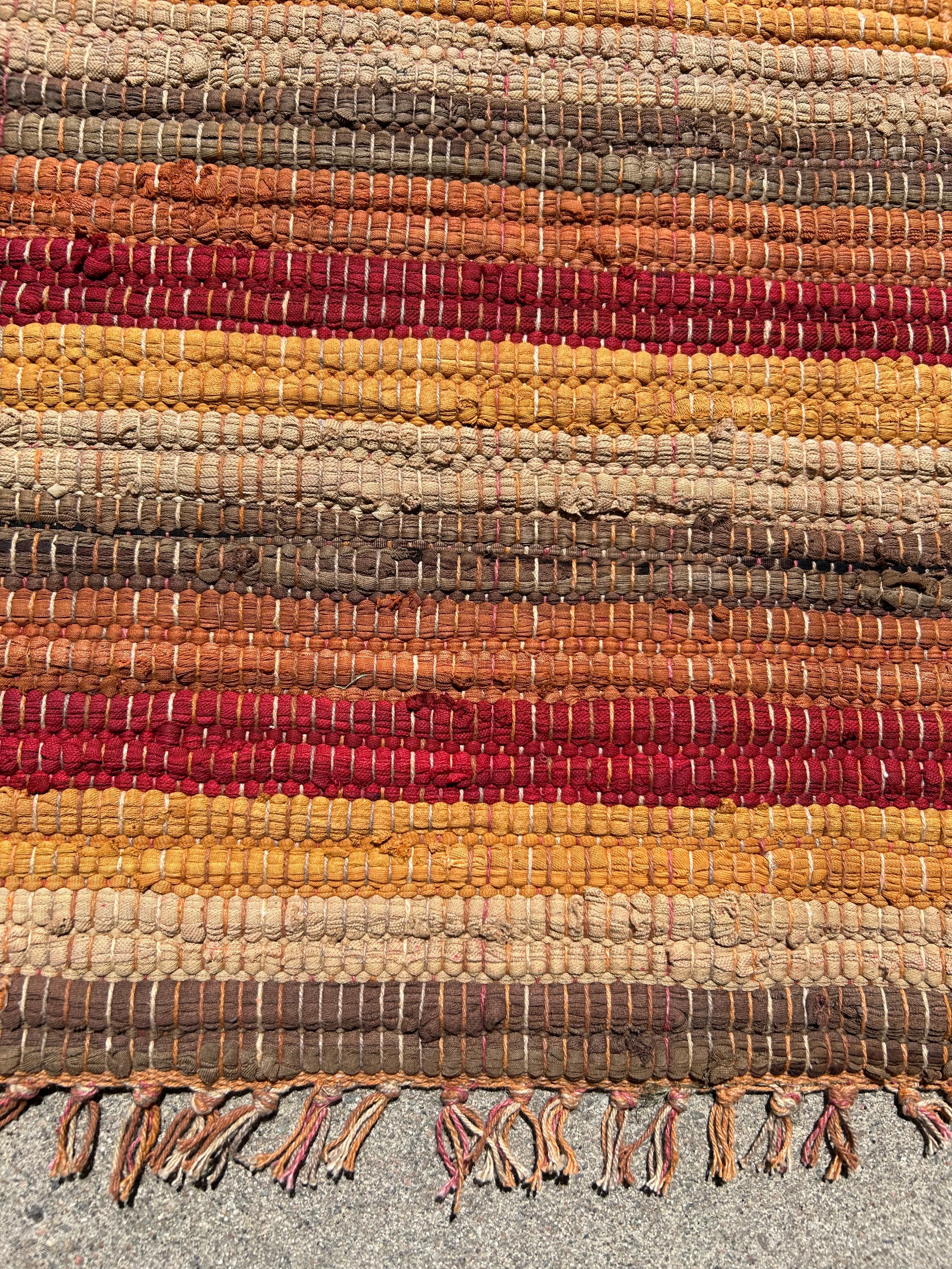 Textured woven mat with multicolored stripes on a gray background
