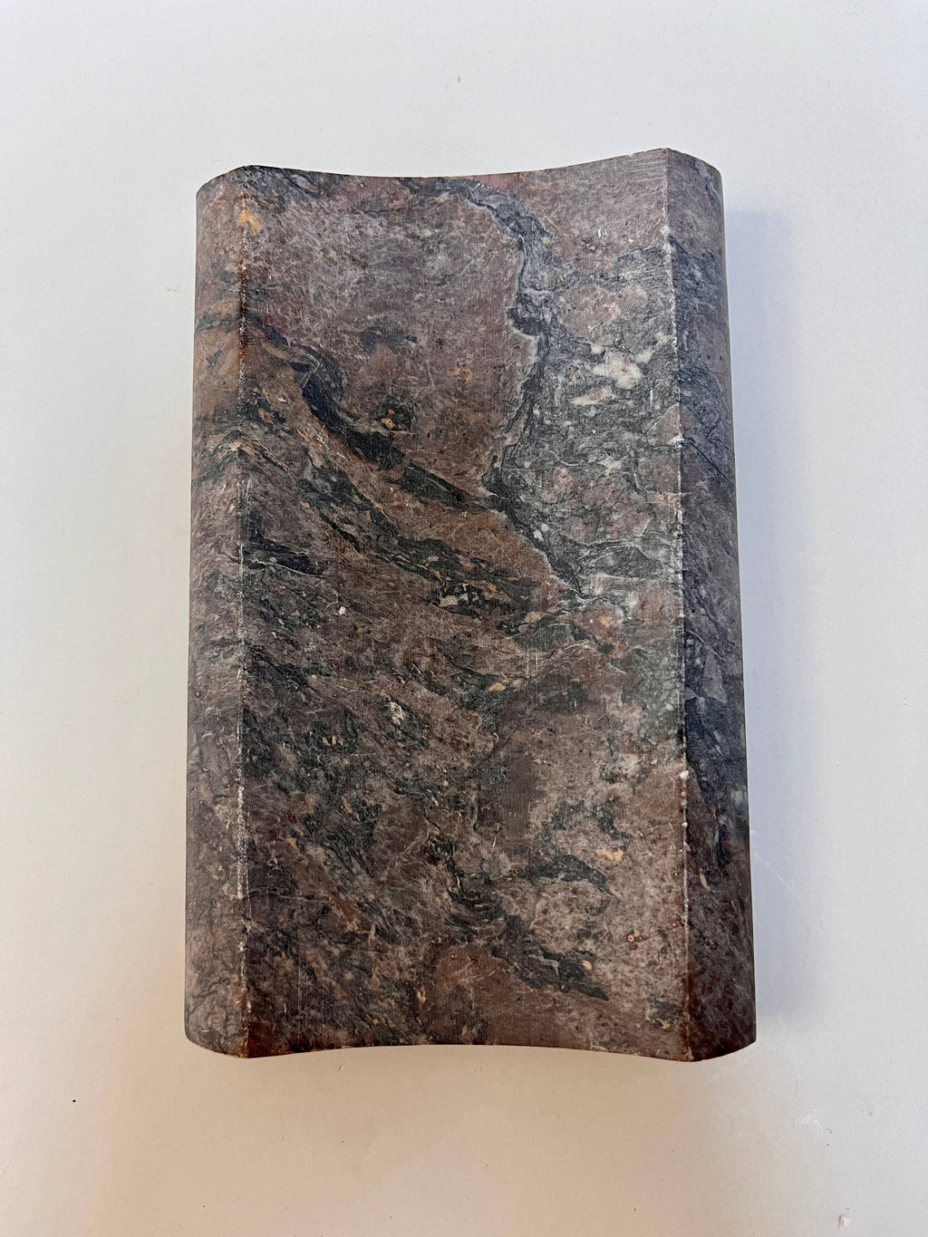 Top View of a soapstone soap dish. Rectangular concave shape neutral multi color.
