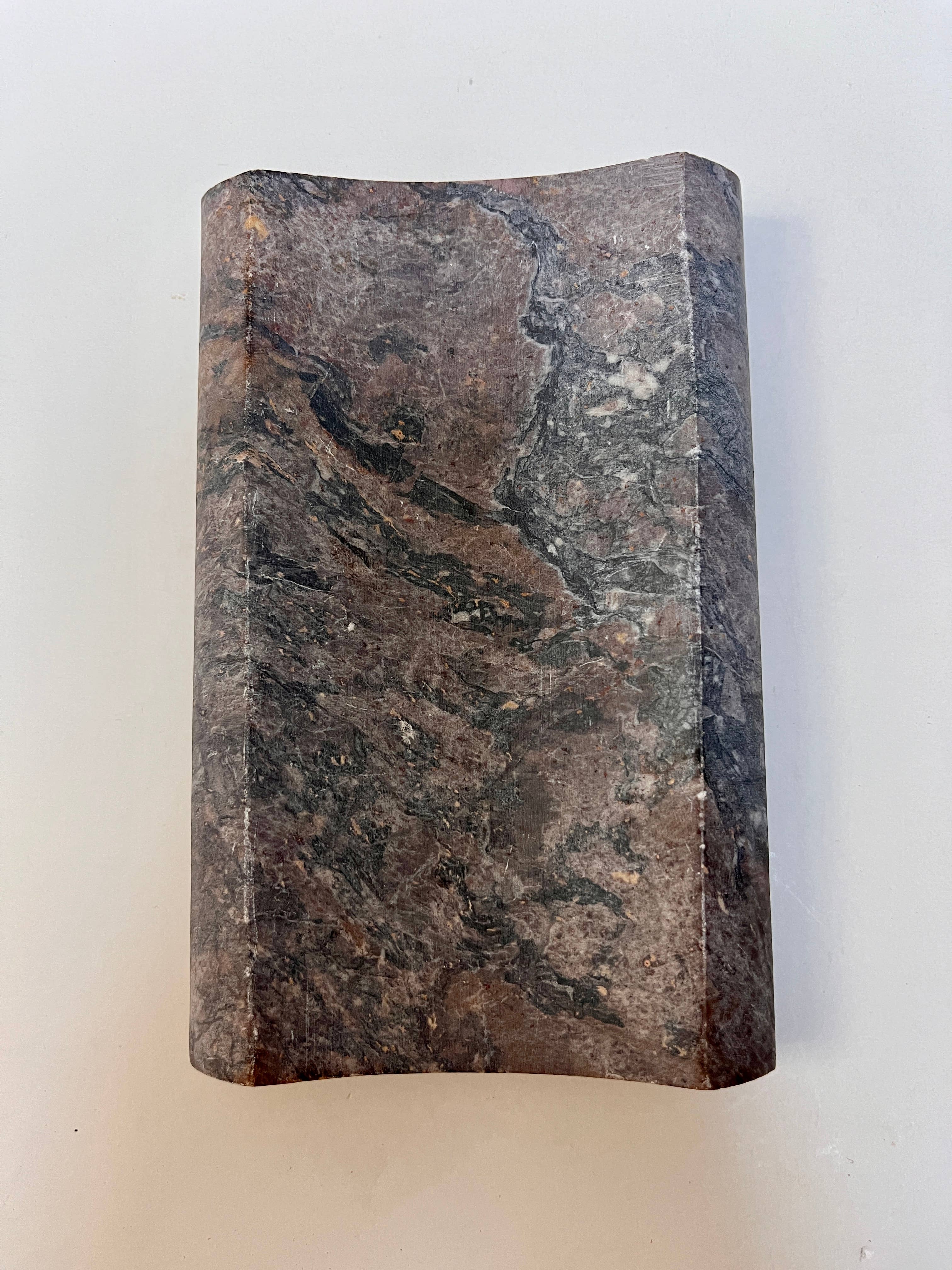 Top View of a soapstone soap dish. Rectangular concave shape neutral multi color.