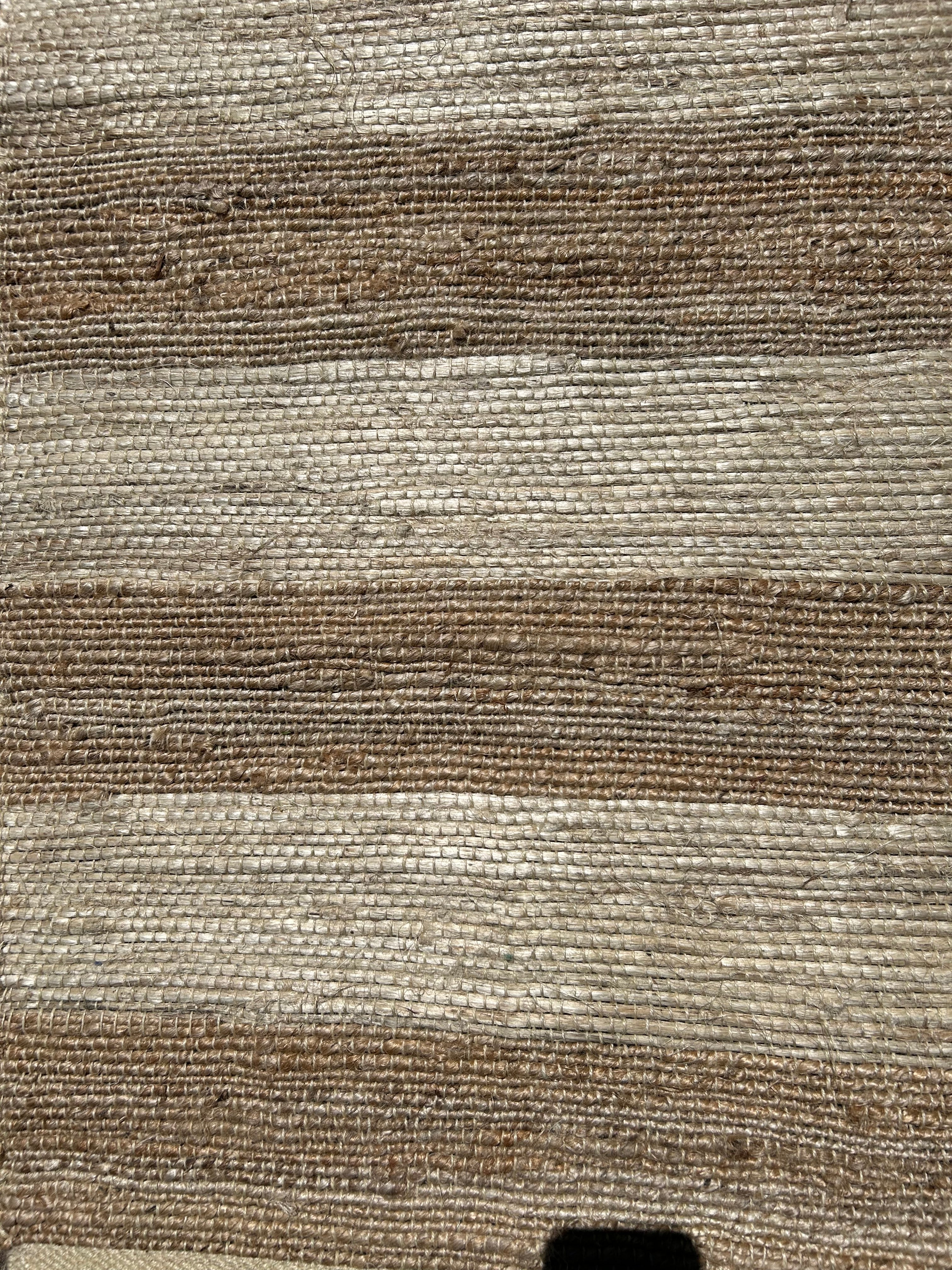 Close-up of a textured brown and beige hemp fabric rug
