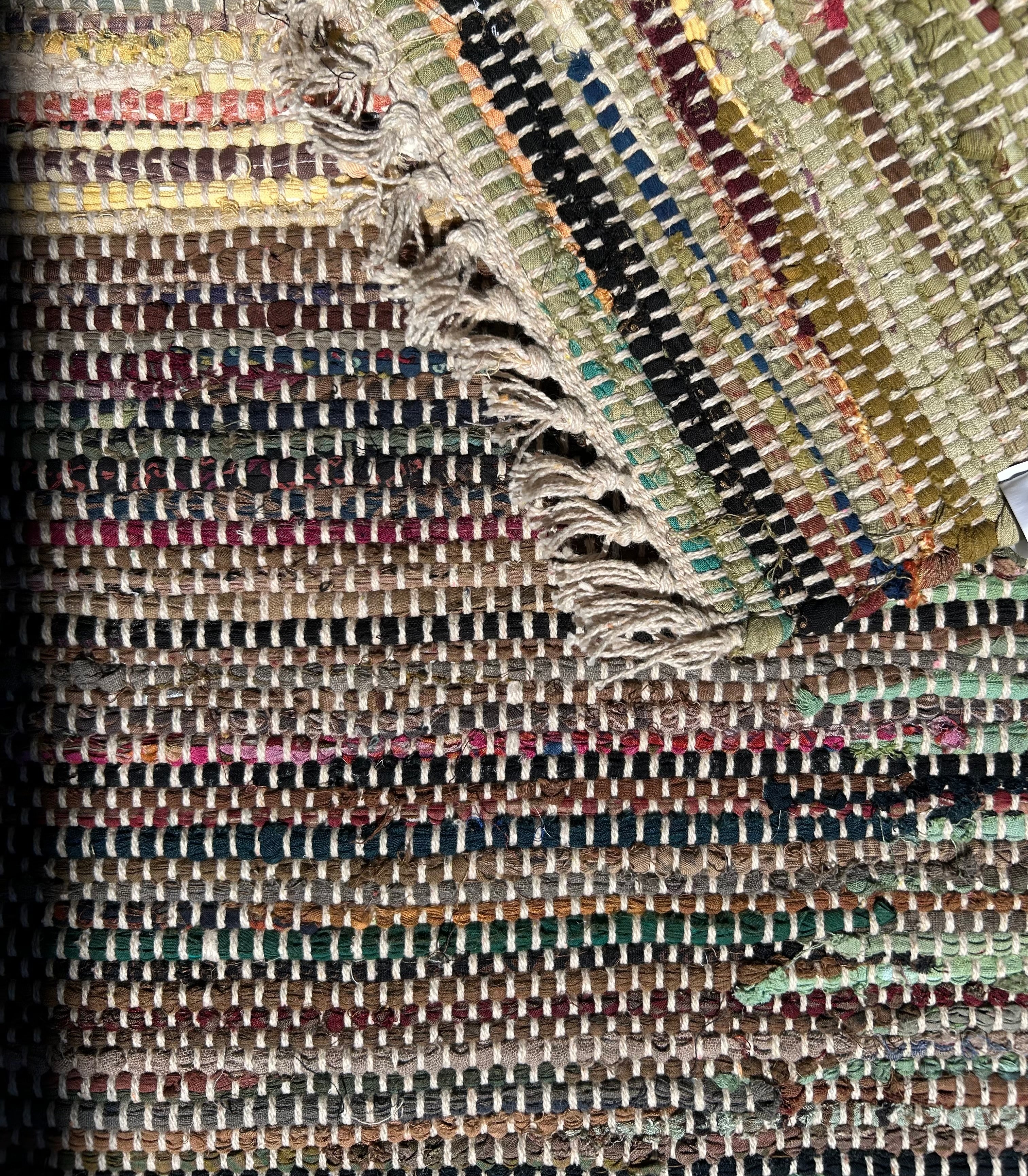 Close-up of a textured rug with multicolored stripes. Showing back same as front.