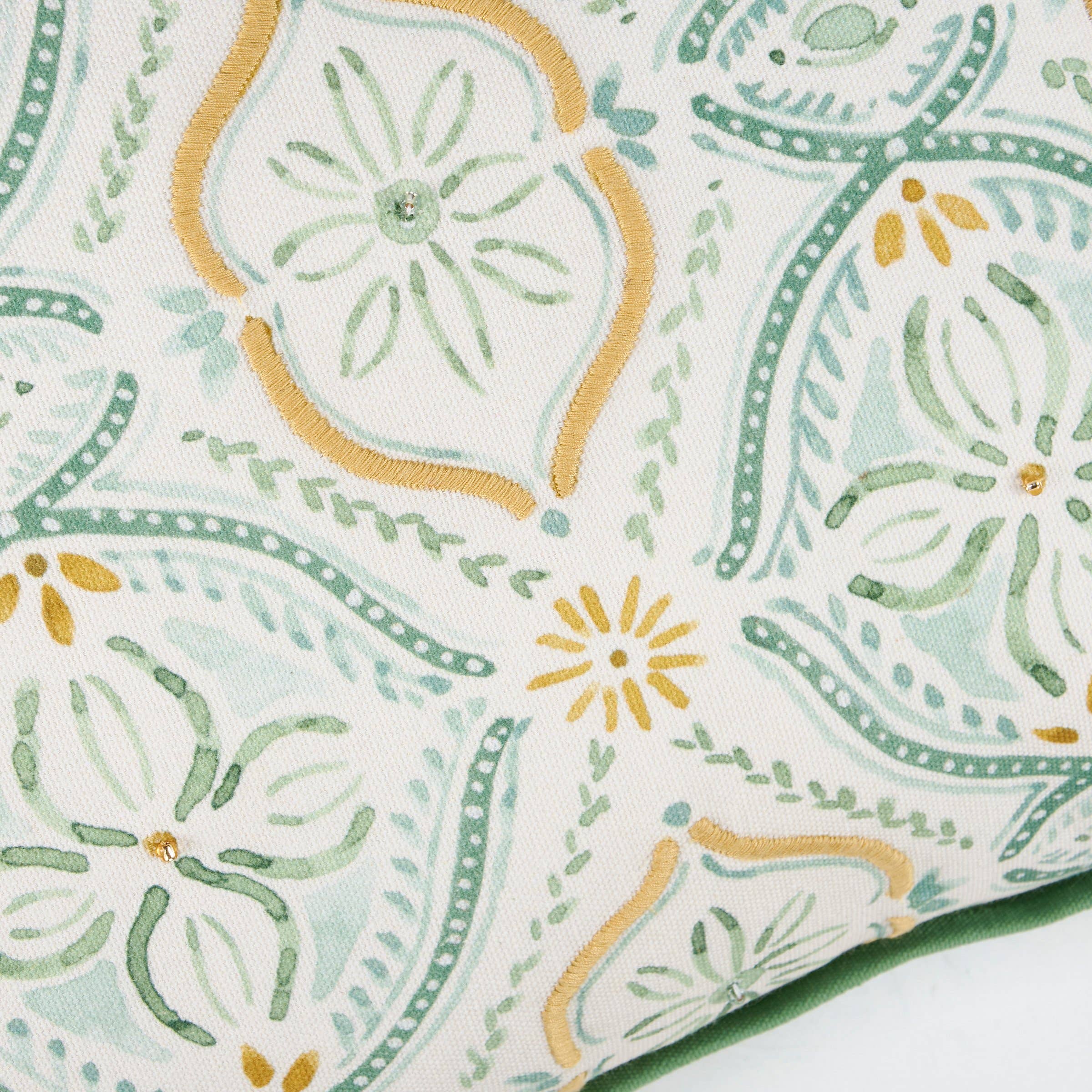 Close-up of a fabric with green and yellow floral pattern on a white background