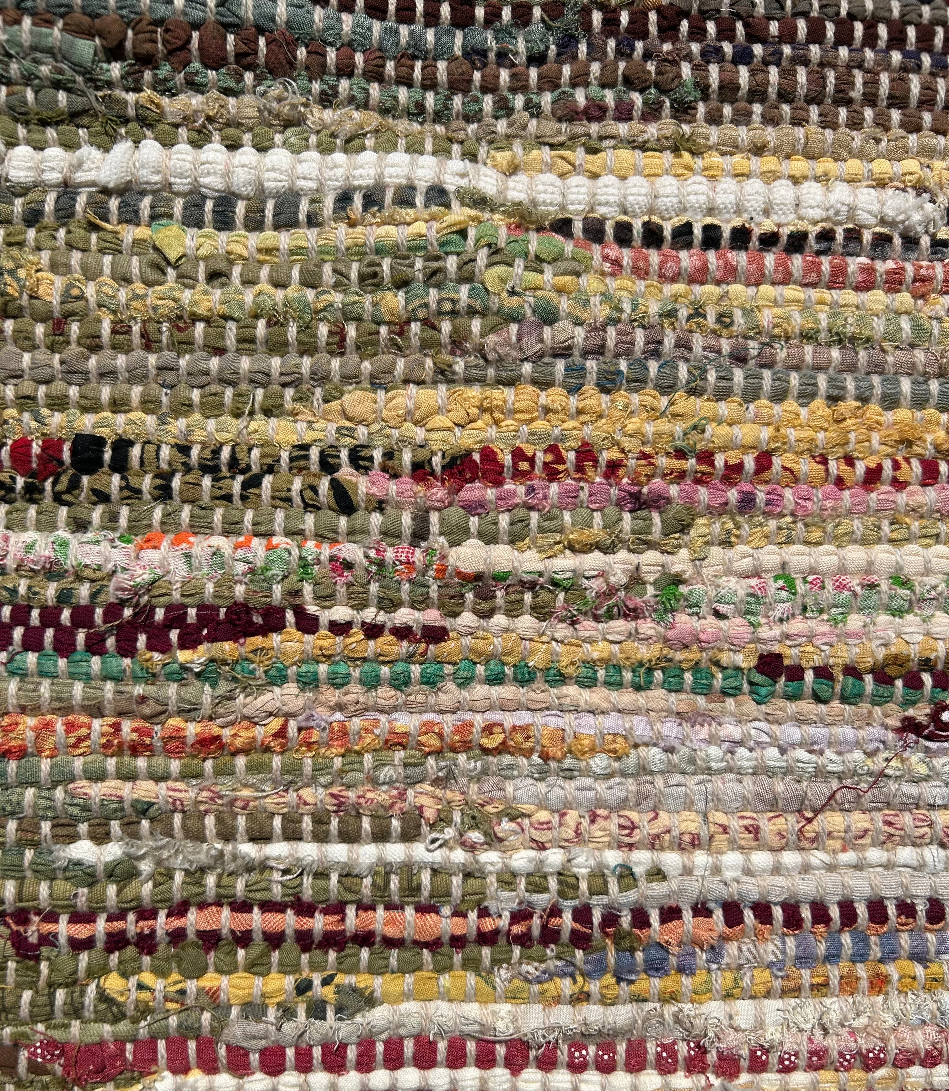 Close-up of a multicolored woven rug with various textures and patterns.