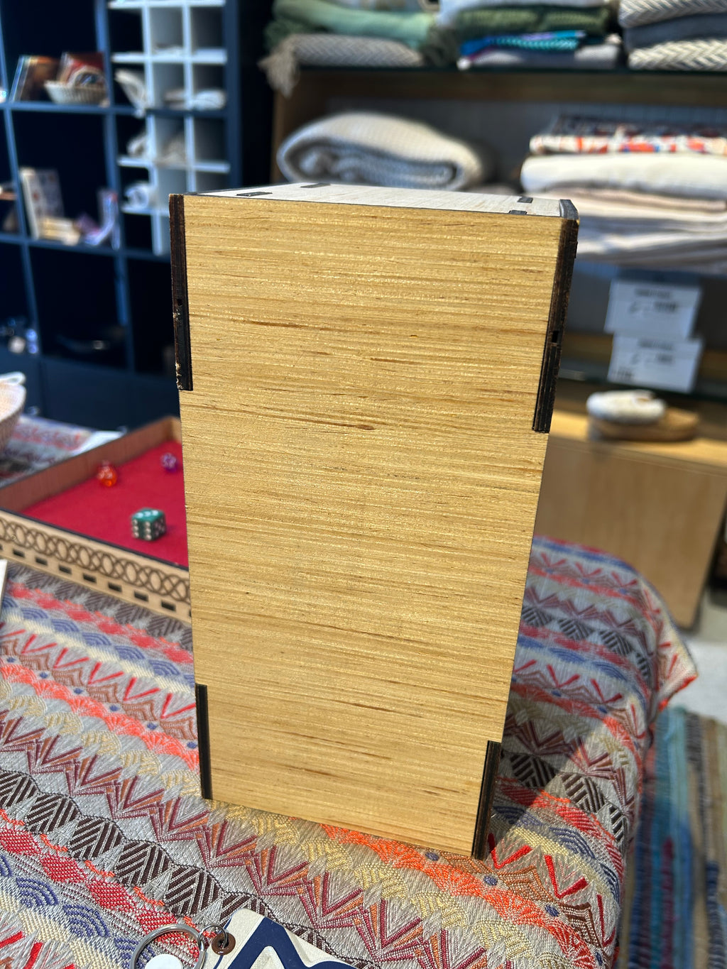 Wooden Dice Tower box back view on a patterned fabric background