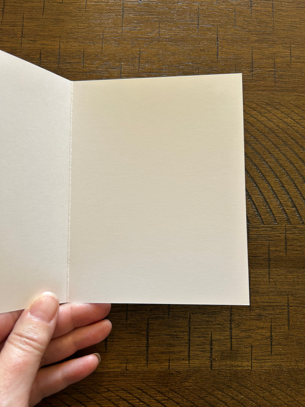 White blank interior of Greeting card on a wood background.