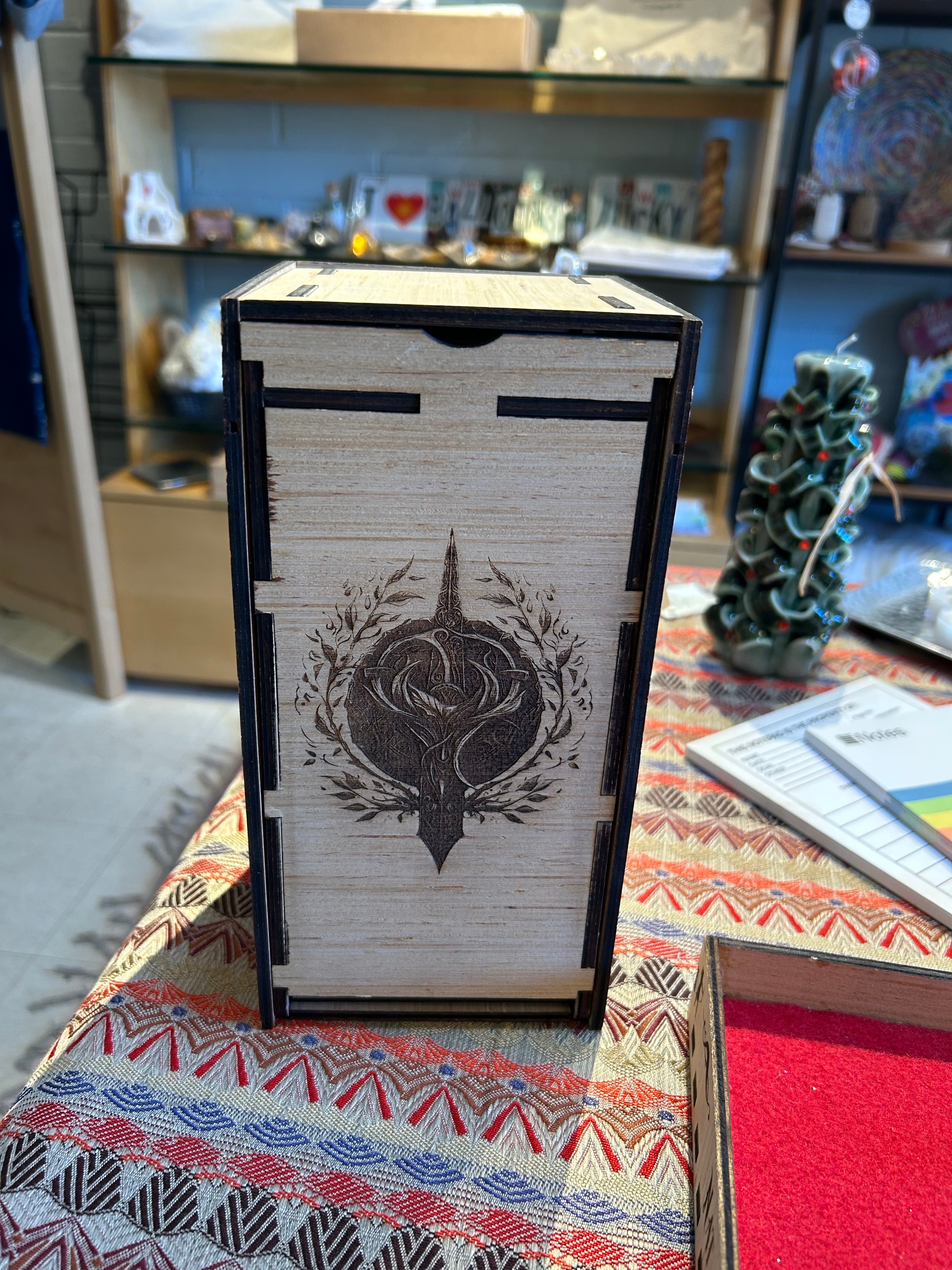 Wooden Dice Tower box with a decorative design on a patterned surface