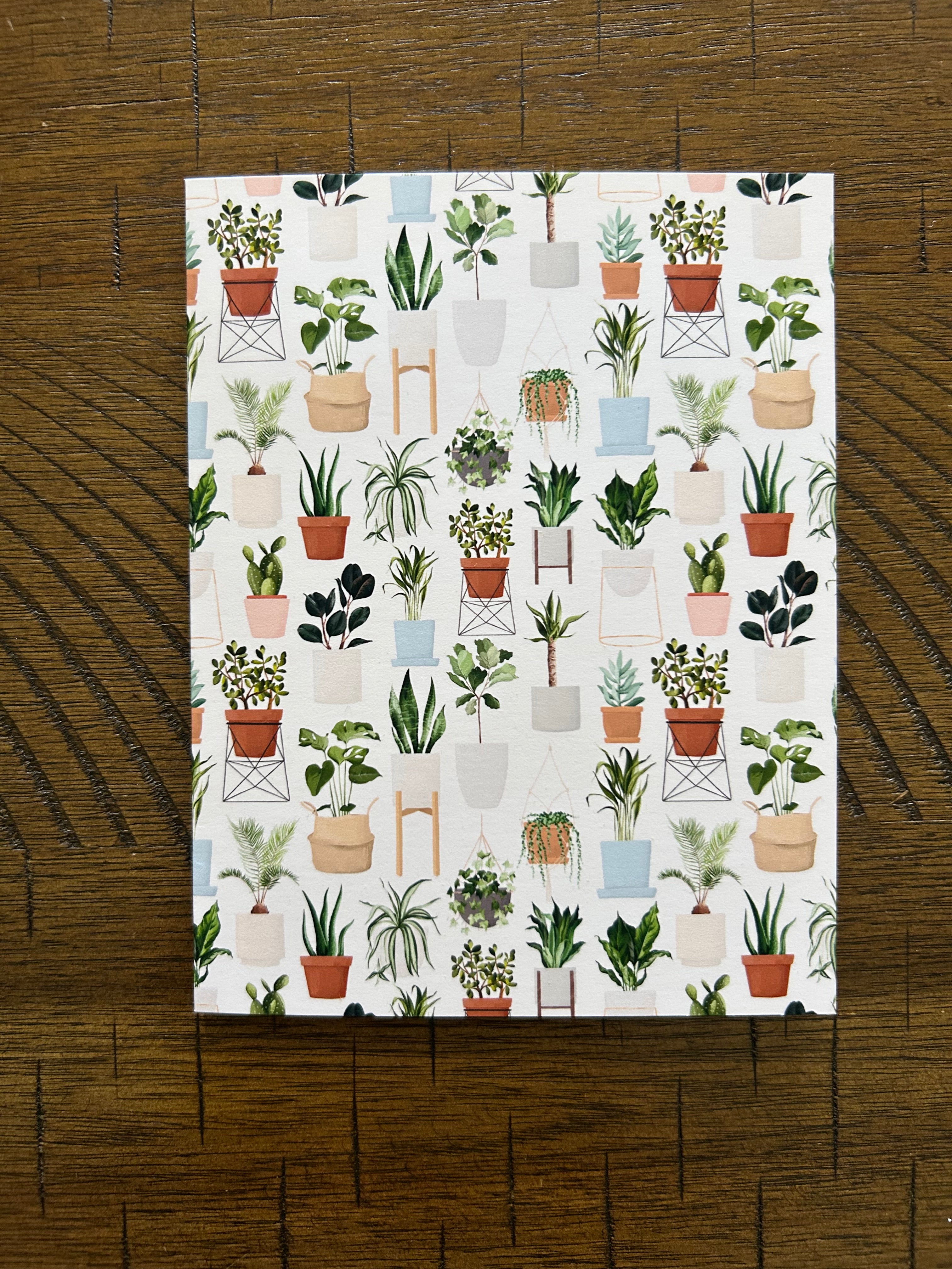 Patterned greeting card with plant designs on a wooden surface