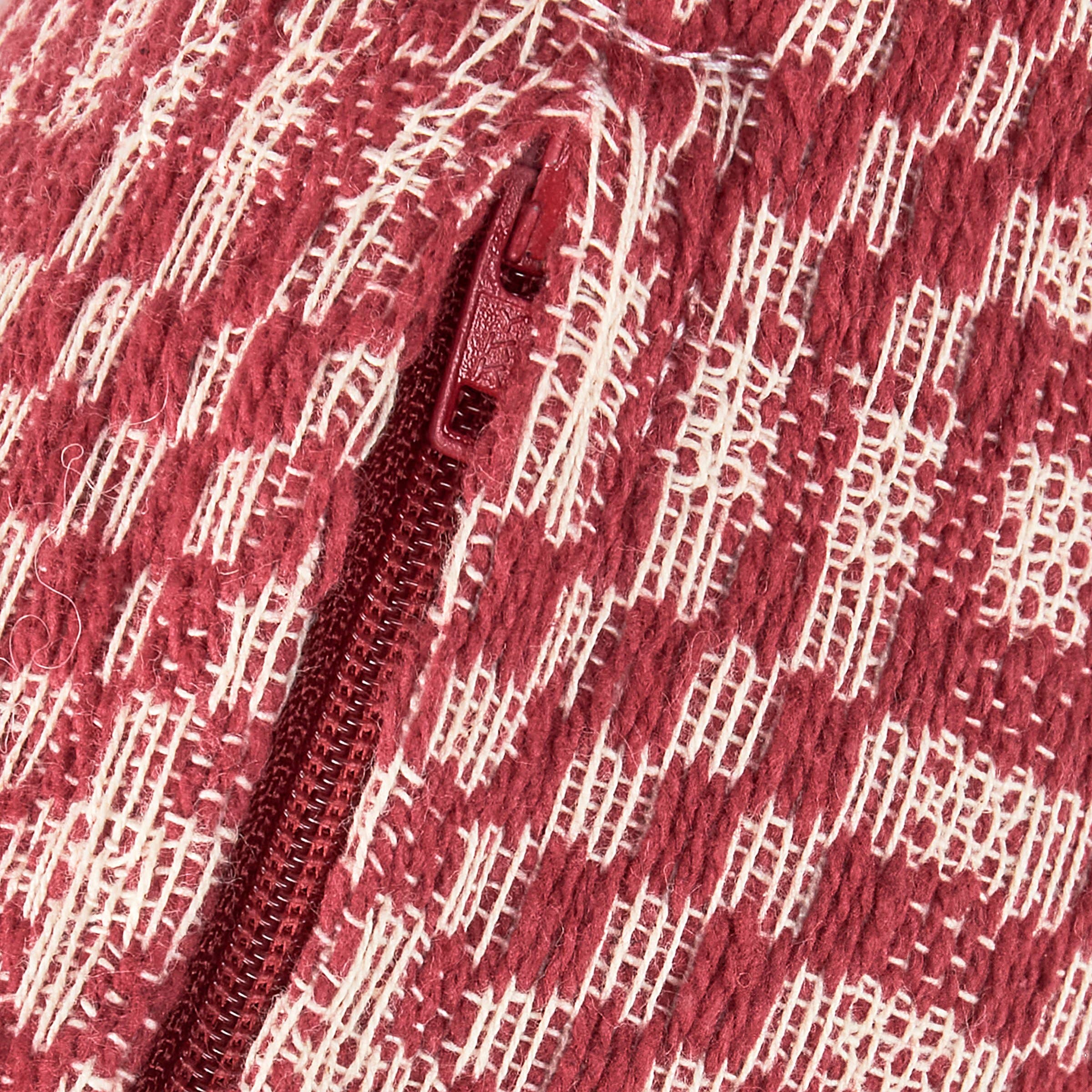 Close-up of a red fabric with a subtle pattern and zipper