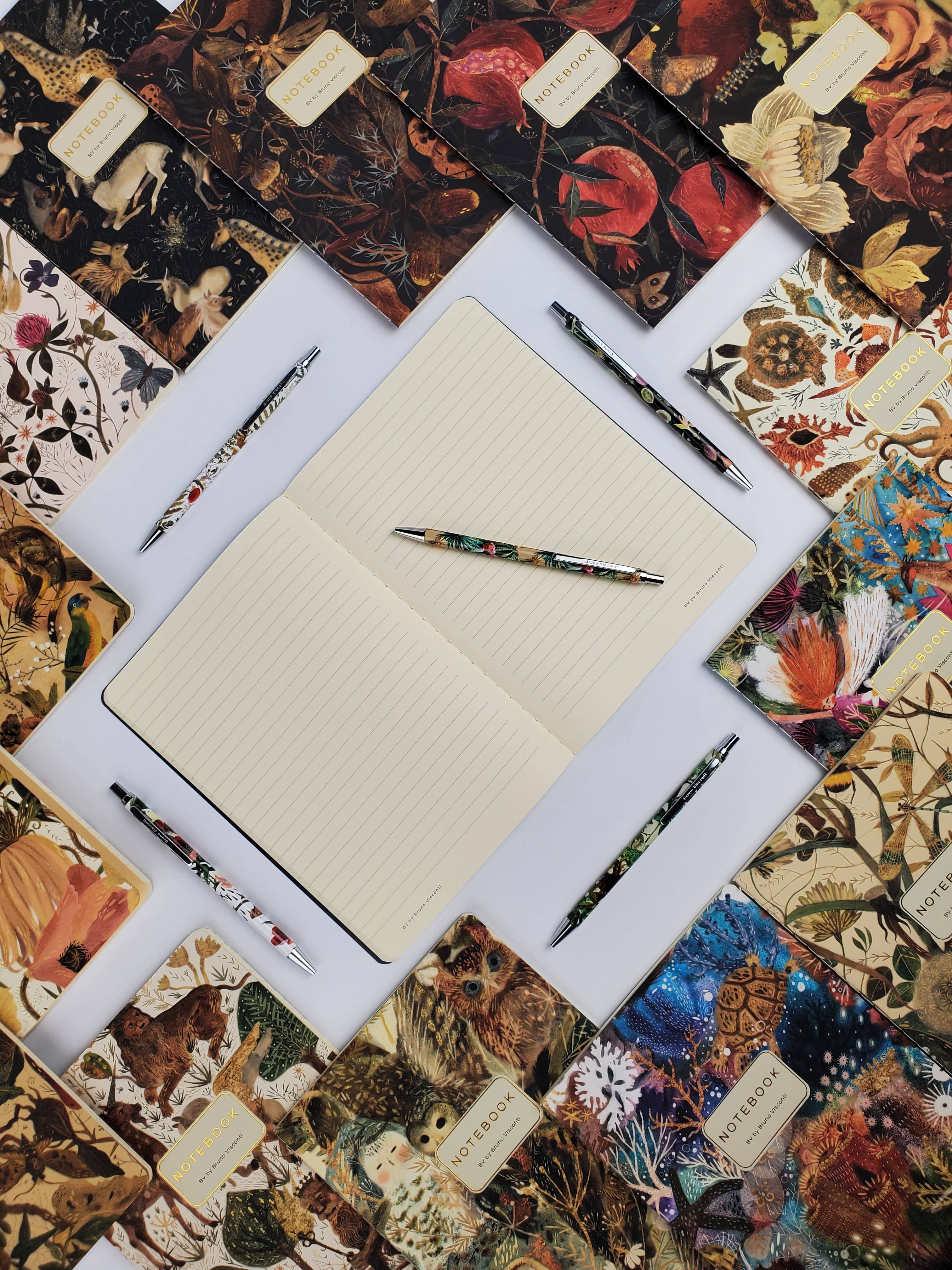 Notebook with pens on a decorative surface with floral patterns