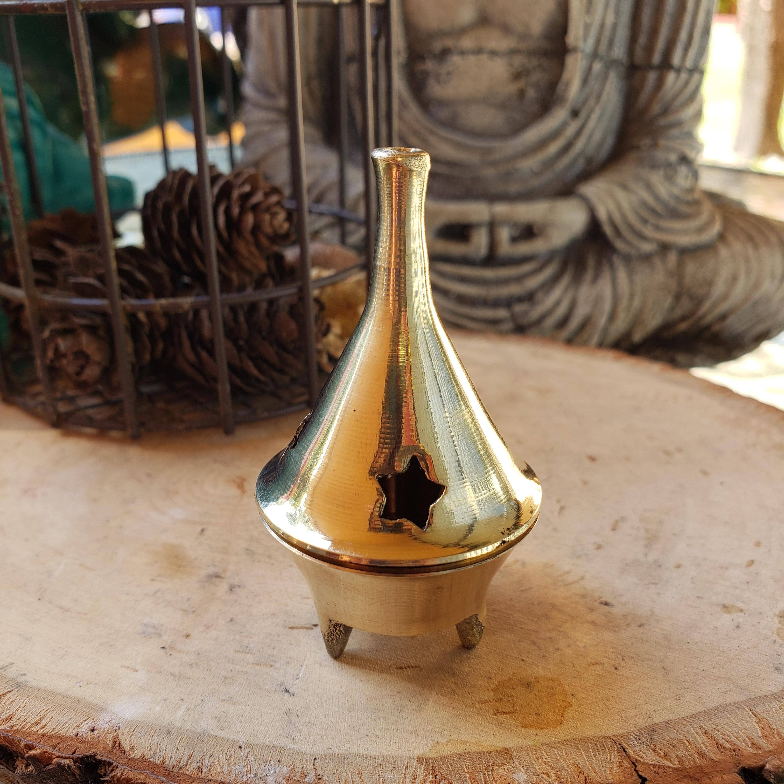Brass incense burner on a wooden surface with a blurred background