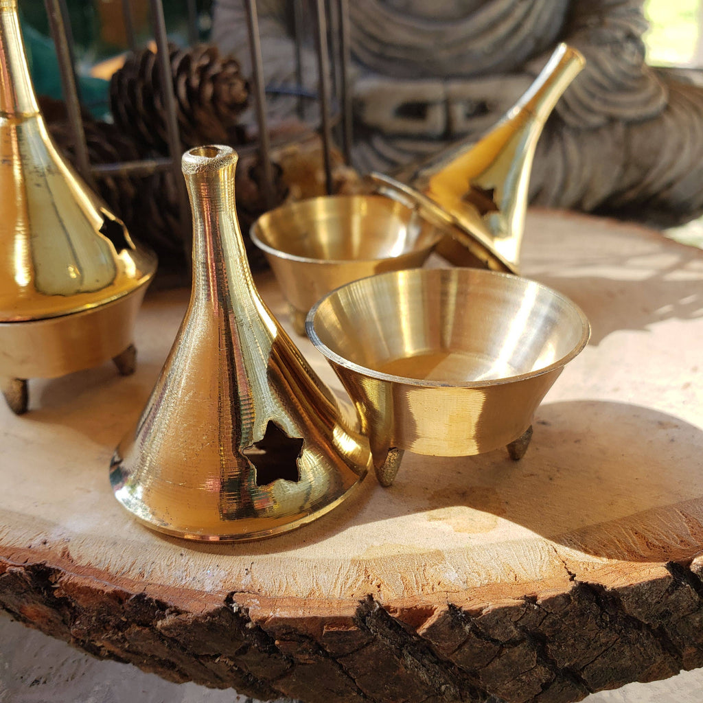 Three Brass incense holders on a wooden surface