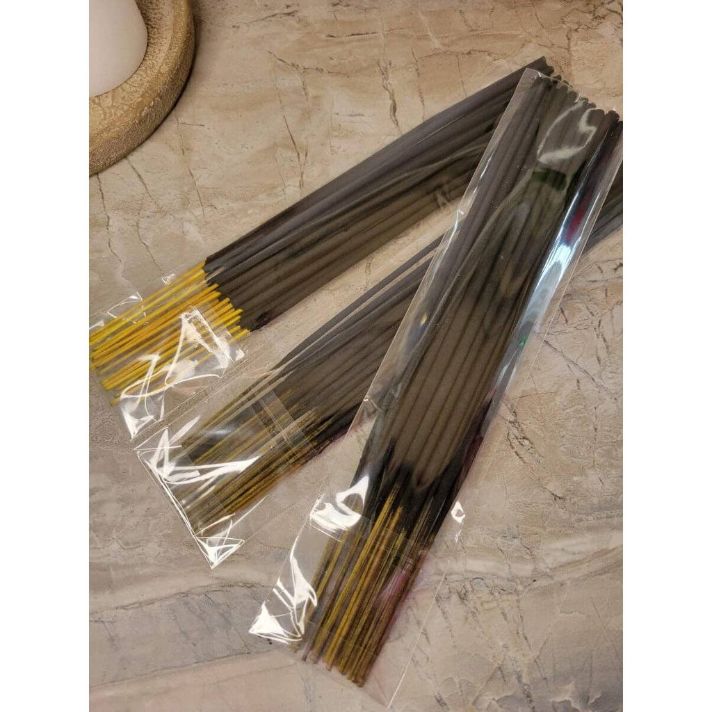 Incense sticks in clear packaging on a stone surface