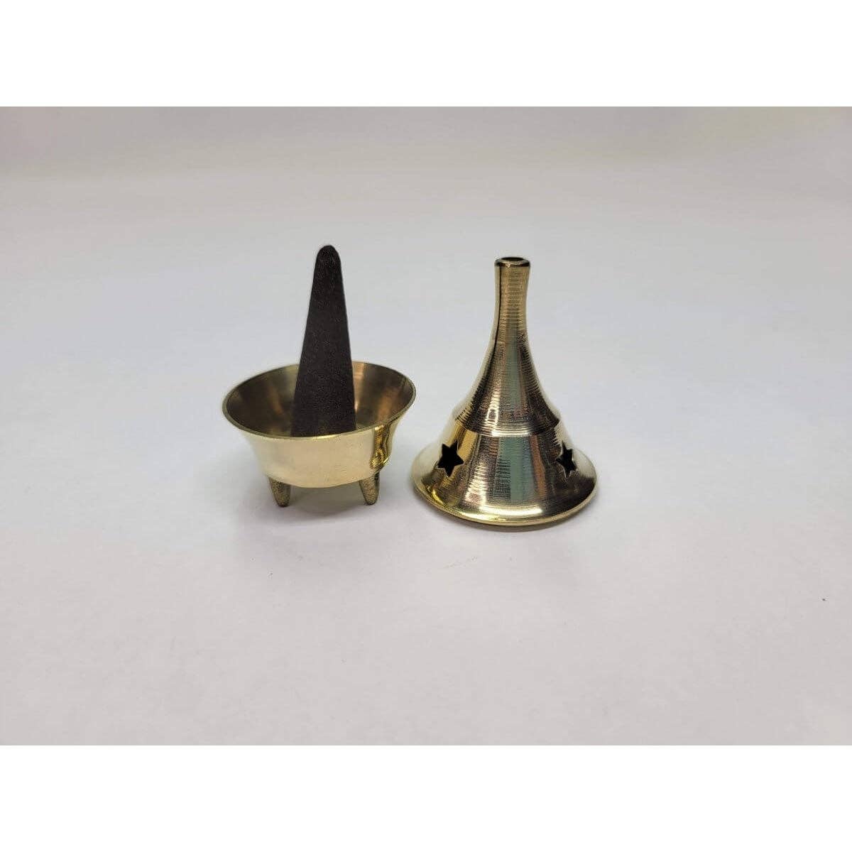 Brass cone incense burner with a black cone and funnel on a white background