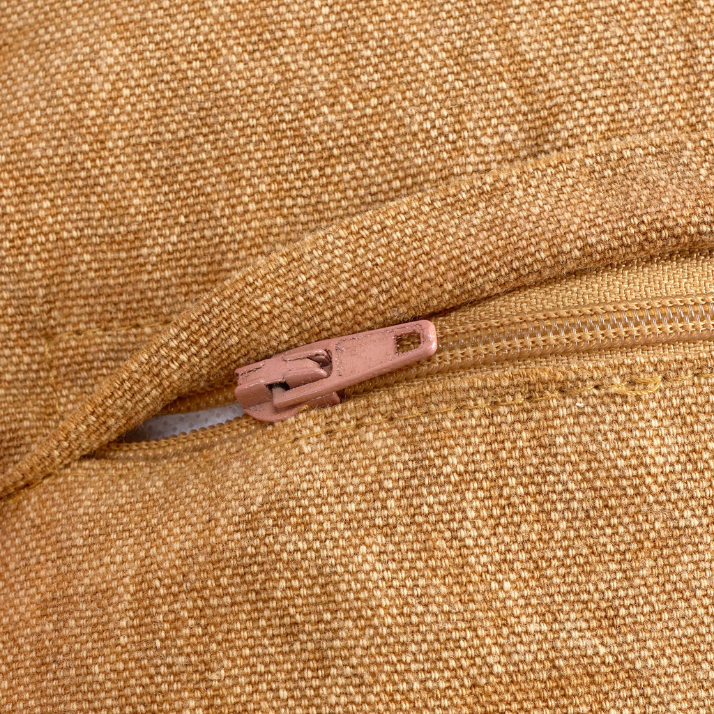 Close-up of a zipper on a textured brown fabric surface