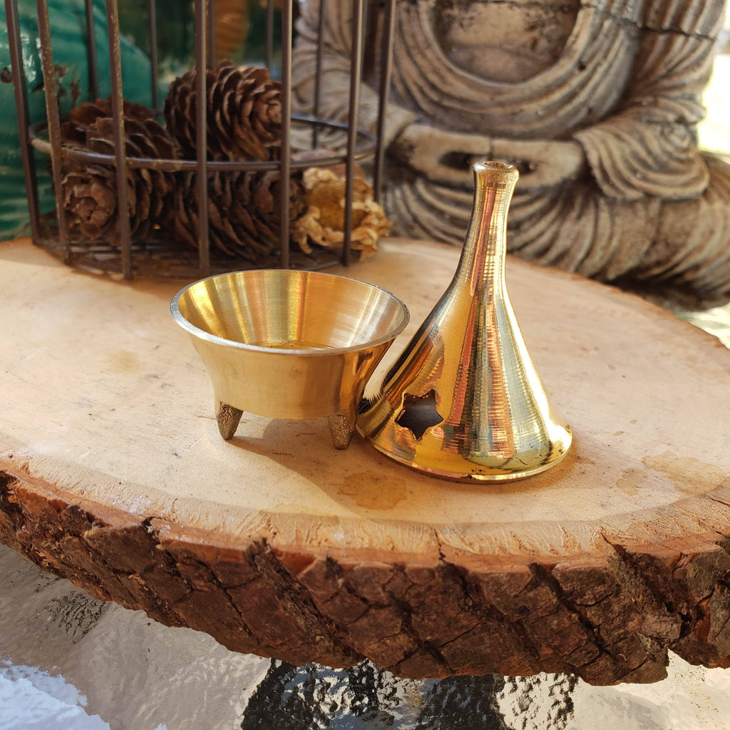 brass incense holder and vase on a wooden surface with decorative background