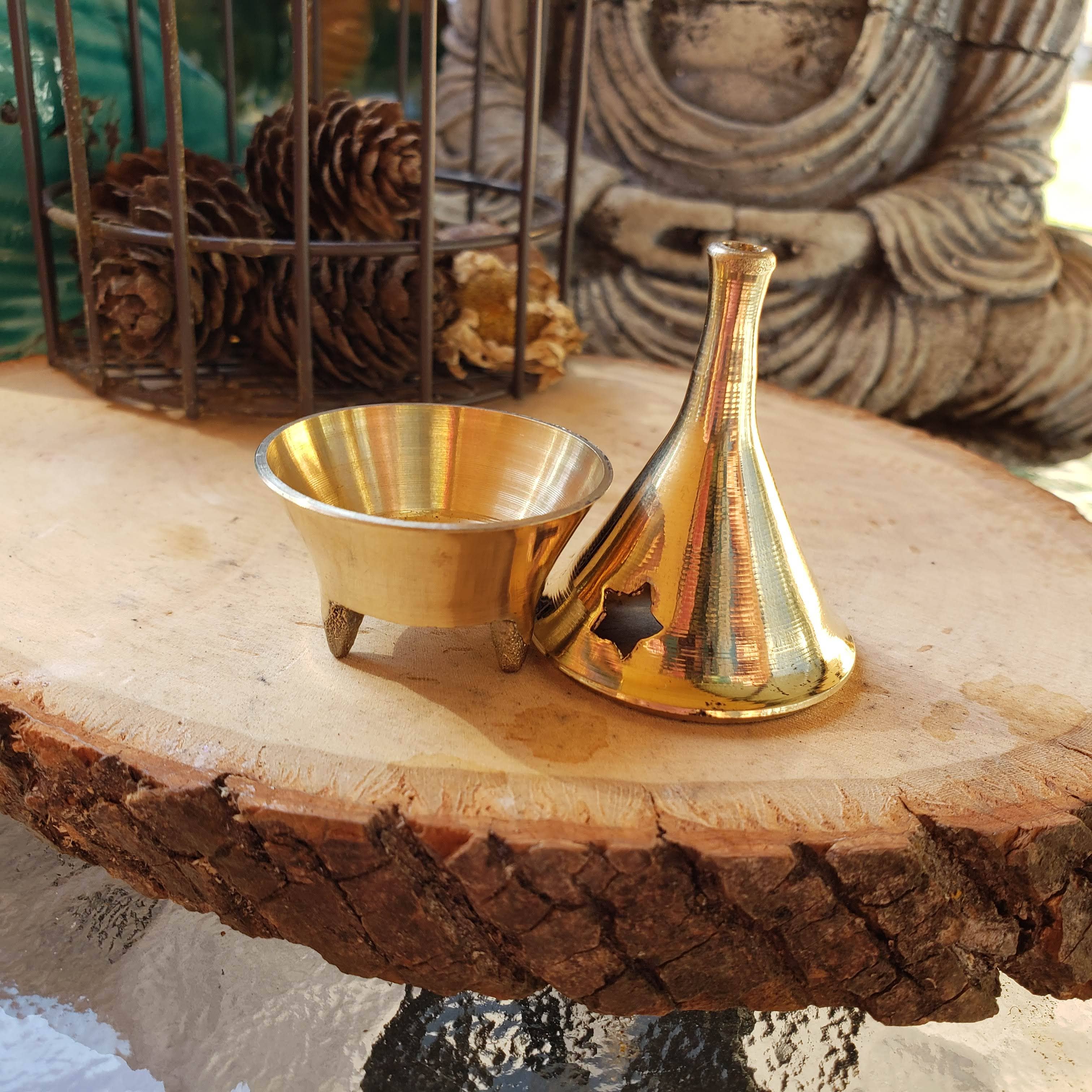 brass incense holder and vase on a wooden surface with decorative background