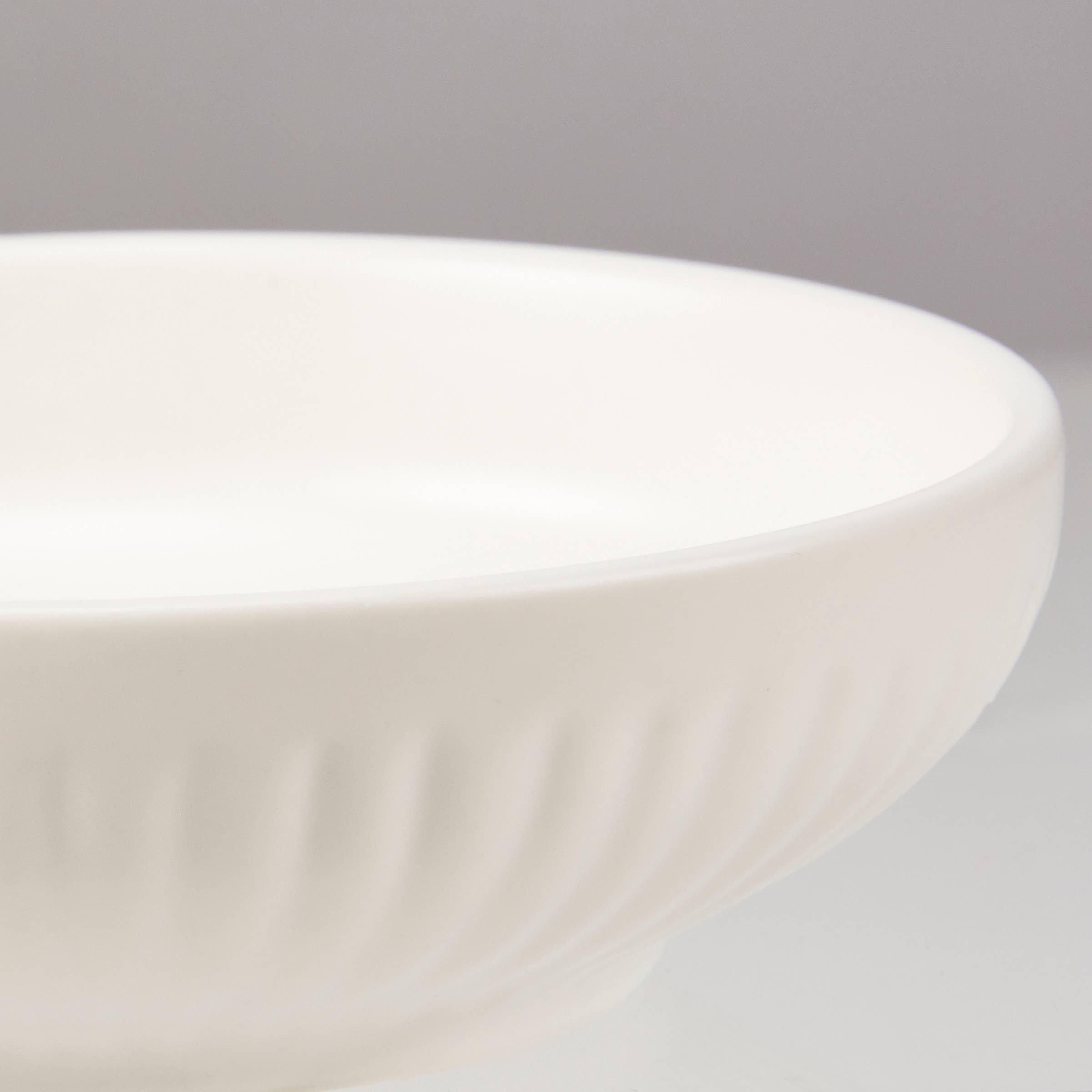 Close-up of a white ceramic bowl on a gray background