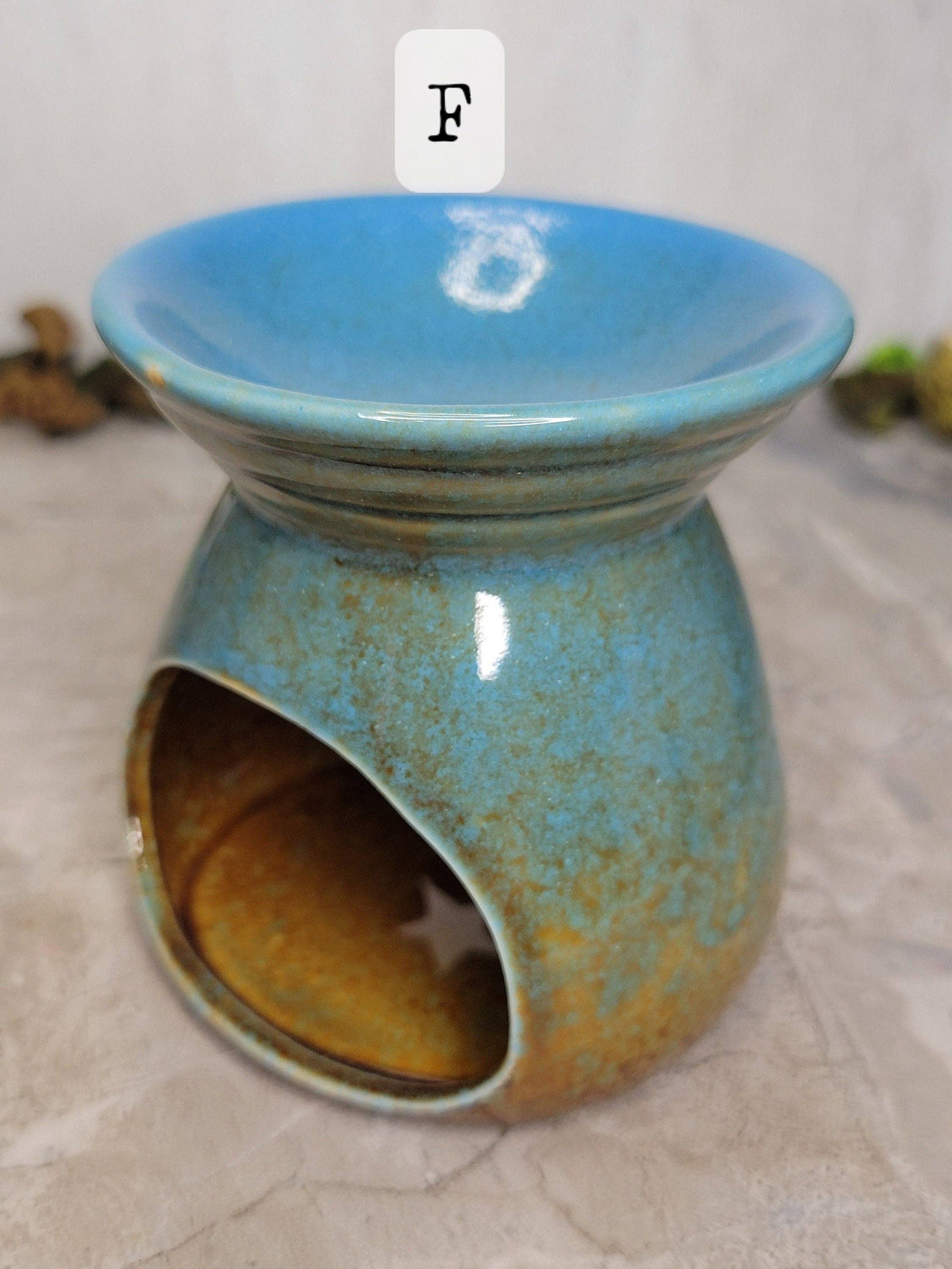 Blue ceramic oil burner on a textured surface