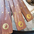 Wooden spoons with star and yin-yang designs on a textured surface