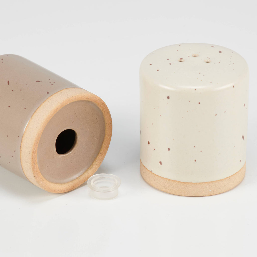 Two ceramic containers with speckled patterns on a white background