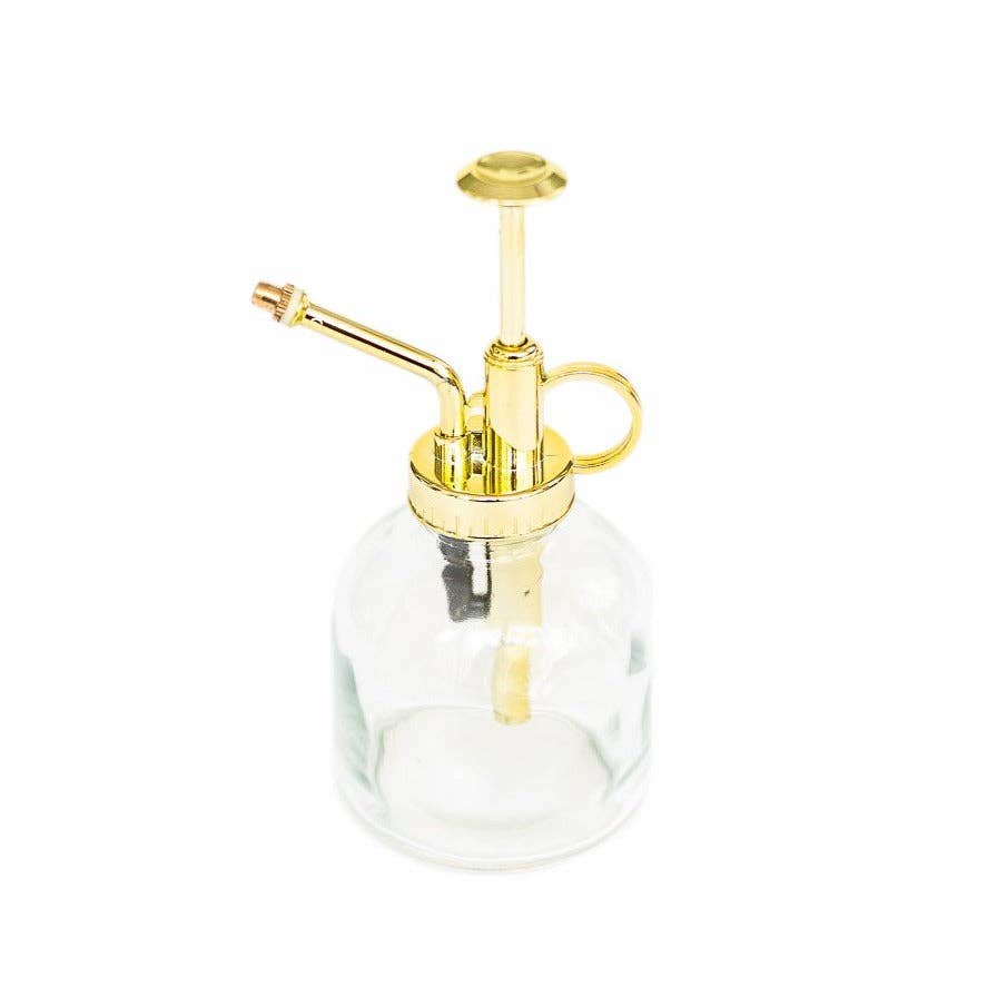 Clear glass bottle with gold plastic nozzle on a white background