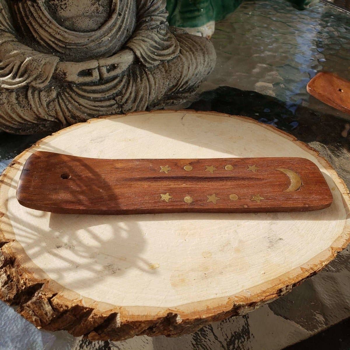 Wooden tool with star and moon designs on a wooden surface