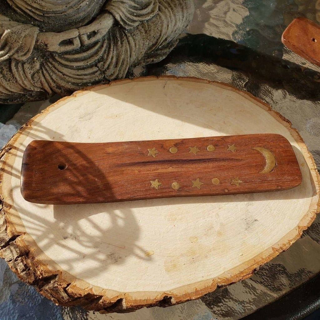 Wooden tool with star and moon designs on a wooden surface