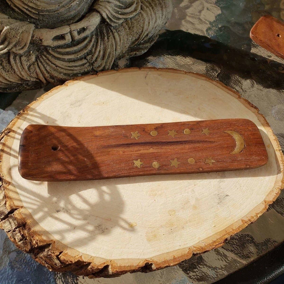 Wooden tool with star and moon designs on a wooden surface