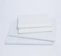 Folded white sateen striped bed sheets on a plain background
