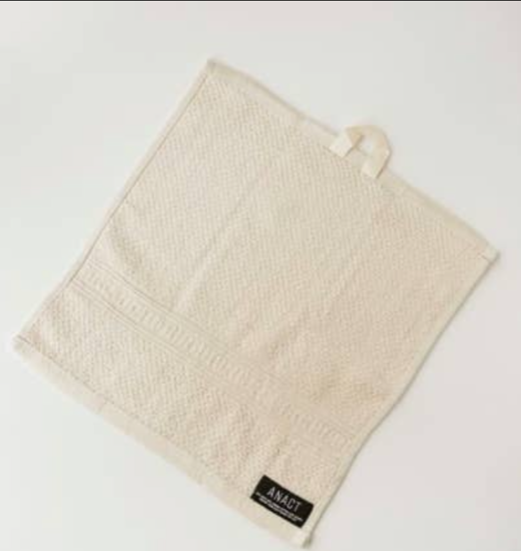 Folded beige hemp-based wash cloth (face towel) by Anact on a light background 